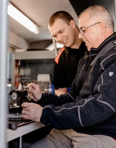 Doug and Quincy McGrail cutting keys on the key machine in the service van
